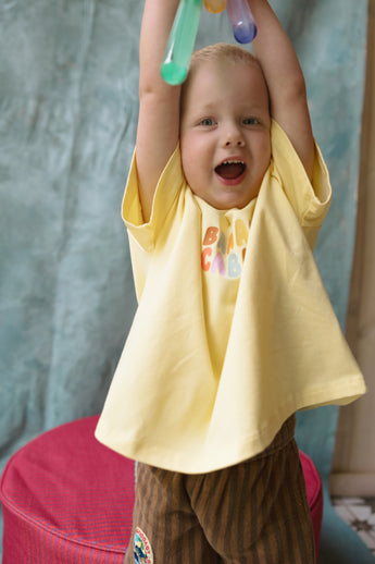 Toddler wearing Banana Cabana Graphic Tee in play setting – made from 95% cotton, 5% spandex