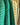 A close-up of striped collared shirts hanging on a rack, featuring a green shirt with thin white stripes, a green shirt with darker green stripes, and a yellow shirt with green stripes.